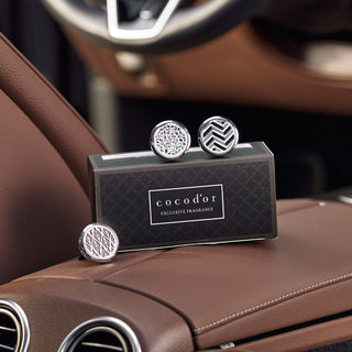 a box with cuff links on a brown leather seat