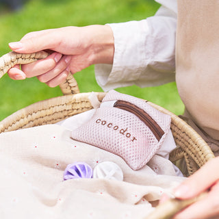 a person holding a basket with a towel and a bag