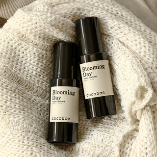two black bottles with white labels on a white blanket