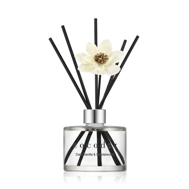 a glass bottle with sticks and a flower