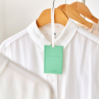 a white shirt with a green tag on it