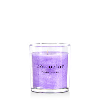 a purple candle in a glass container