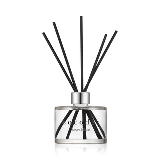 a glass bottle with sticks in it