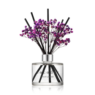 a glass bottle with purple flowers in it