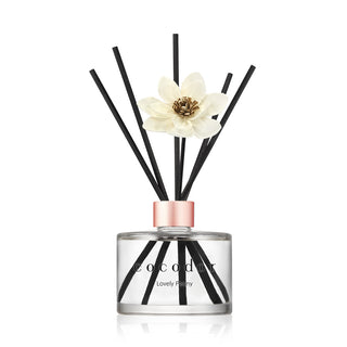a glass bottle with sticks and a flower