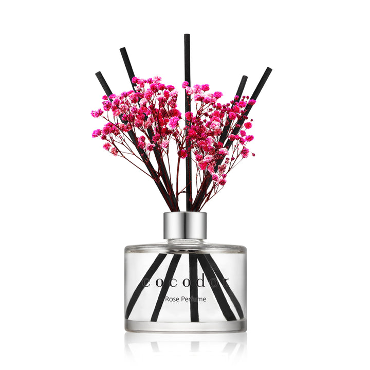a glass bottle with pink flowers in it