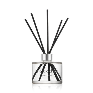 a glass bottle with sticks in it