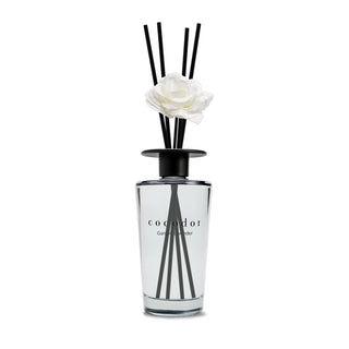 a glass bottle with a white flower in it